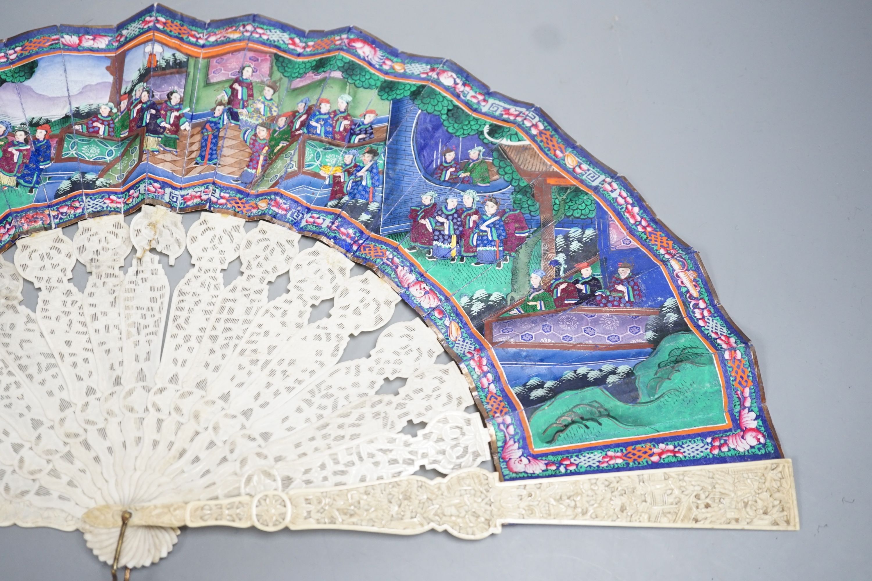 A 19th century Chinese export pierced ivory and painted paper leaf fan, in box. Fan 28cm long